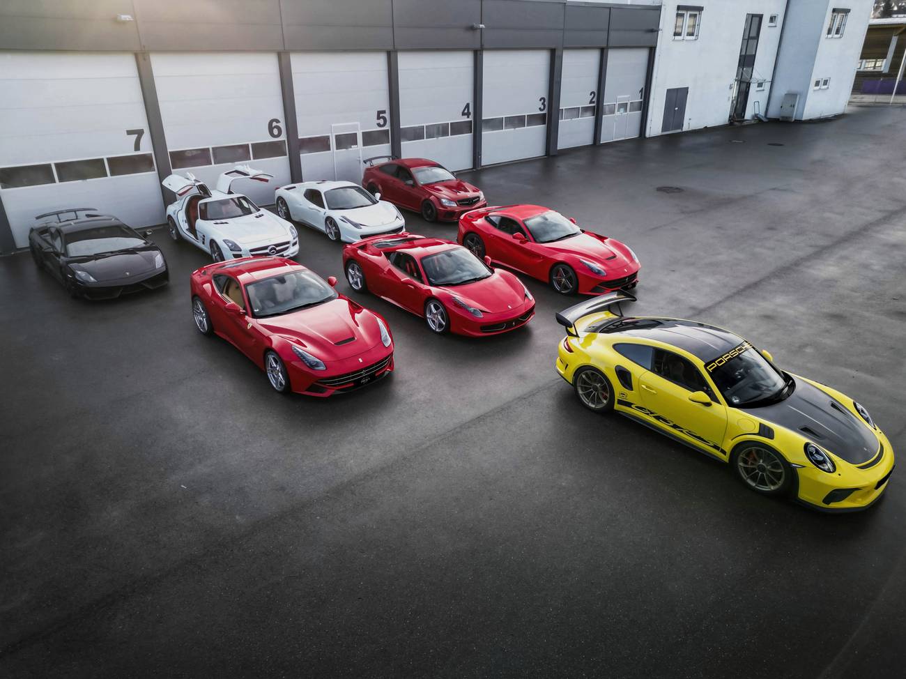 Ferrari, Porsche, Lamborghini und Mercedes-AMG vor der Halle